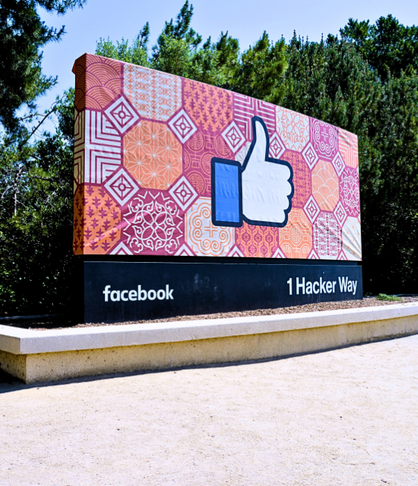 Sign showing the thumbs-up icon that reads "facebook" and "1 Hacker way"