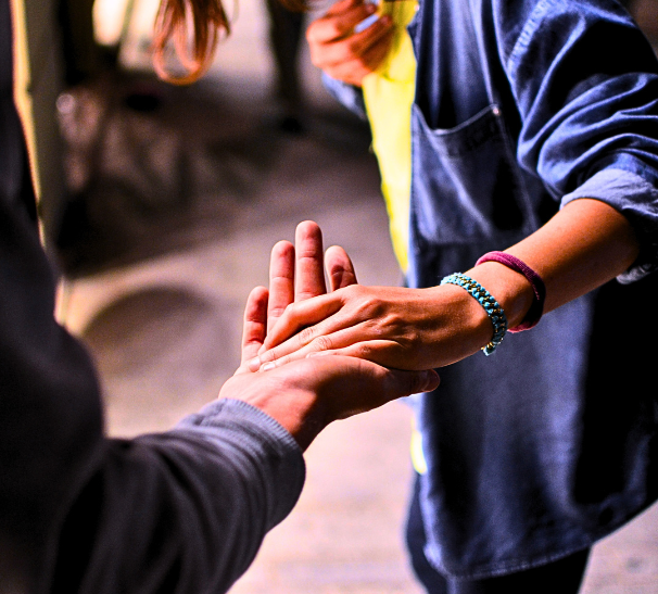 Two people who have reached out to each other and clasped hands